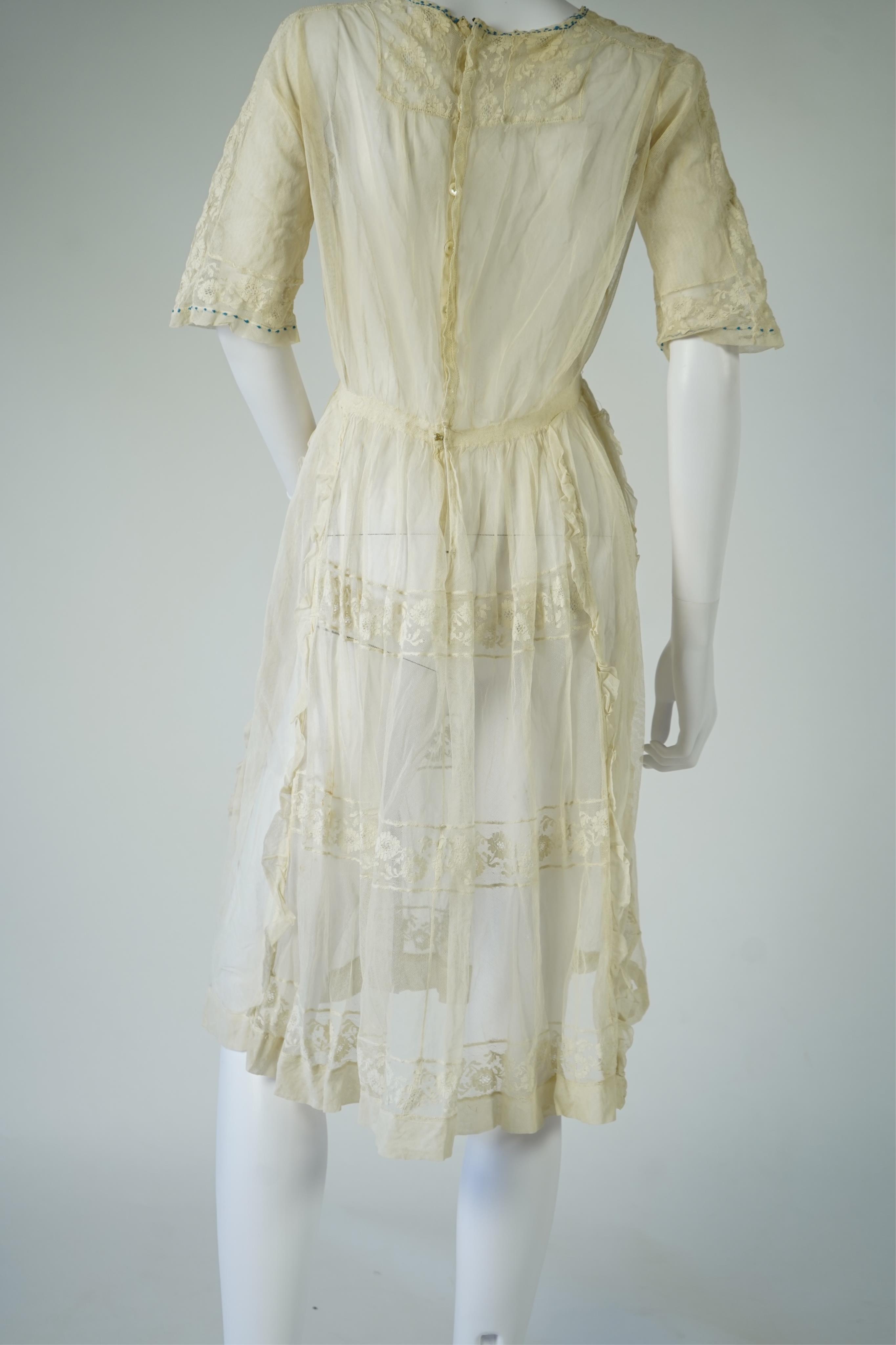 An early 20’s cream net ladies summer dress and net petticoat, designed with a lace inset front skirt, yolk and sleeves.103cm long. Condition - both need re-laundering and some seams tidying.